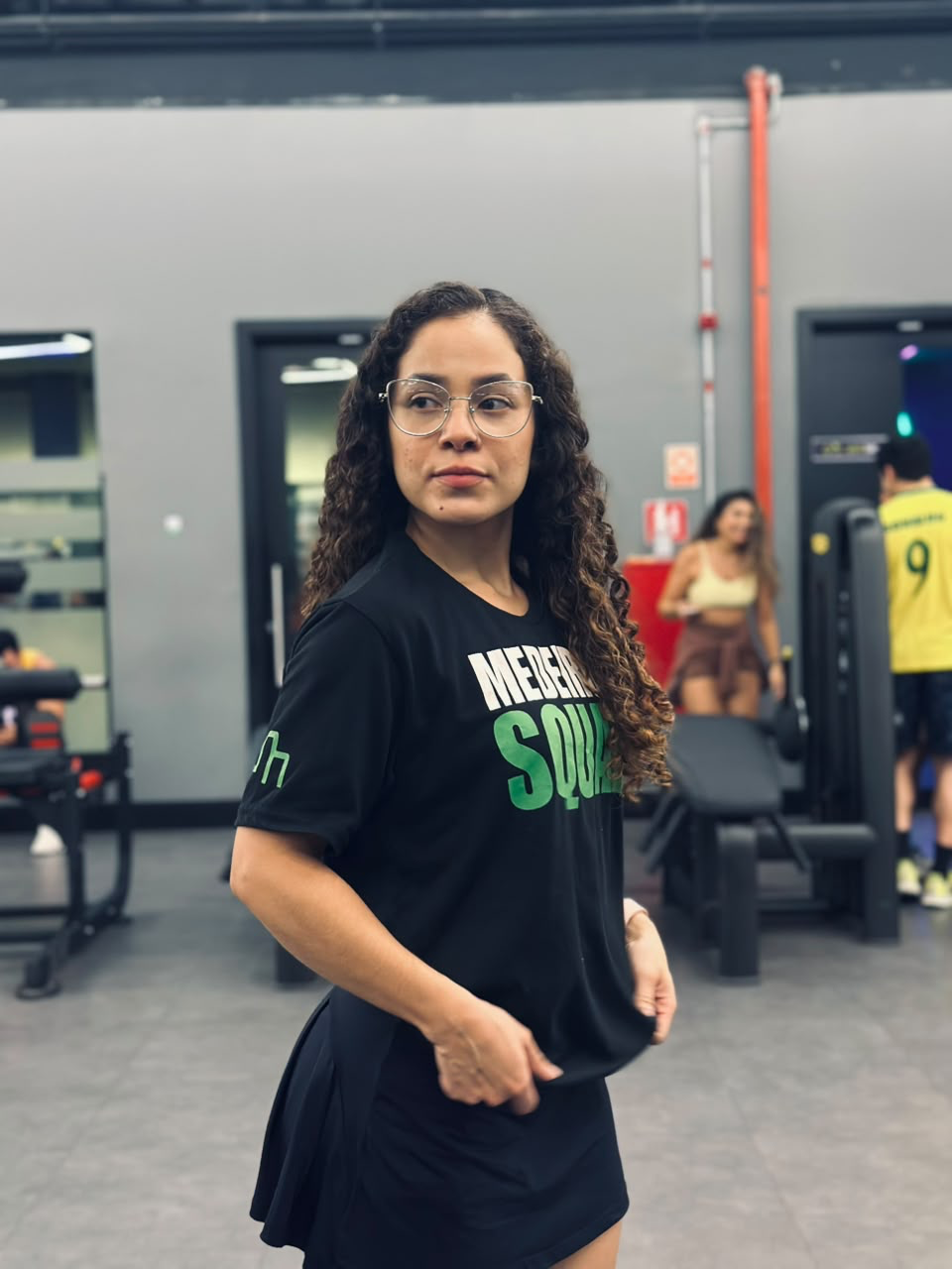 Aluna com camiseta do time, treino natural feminino Medeiros Squad